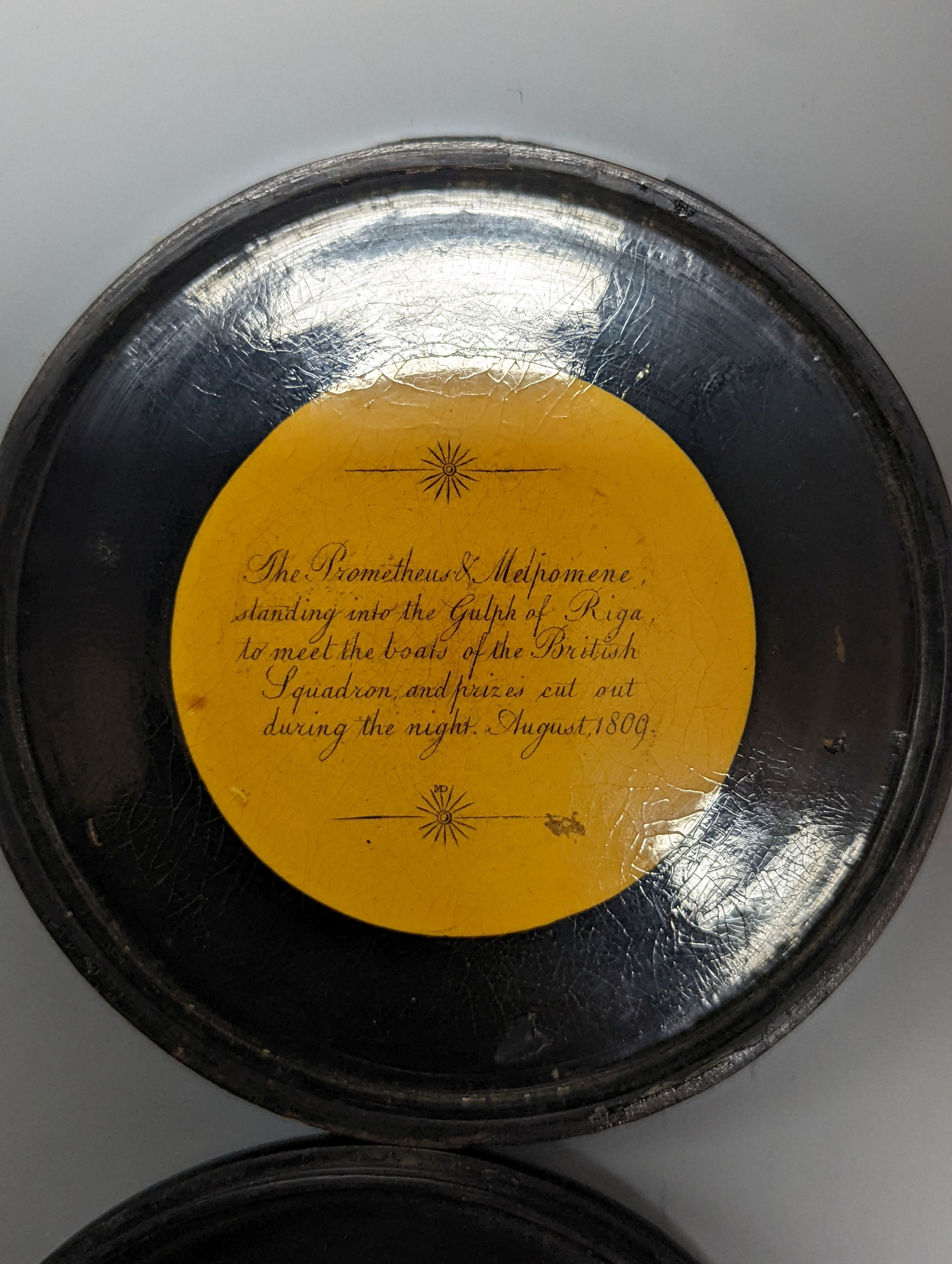 A Napoleonic papier-mâché box, painted with named battleships, 1809, inscribed within, 9cm.
